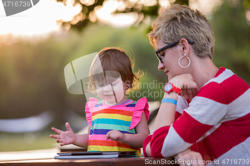 Image of mom and her little daughter using tablet computer