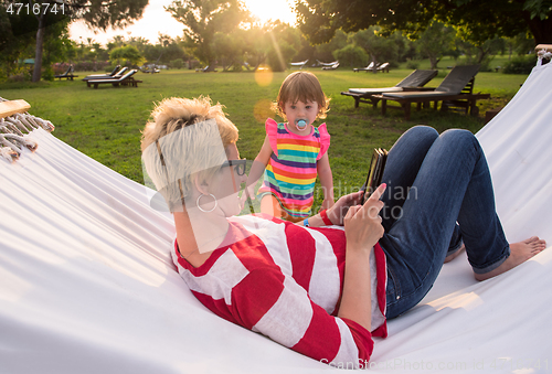 Image of mom and a little daughter relaxing in a hammock