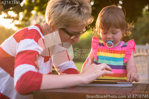Image of mom and her little daughter using tablet computer