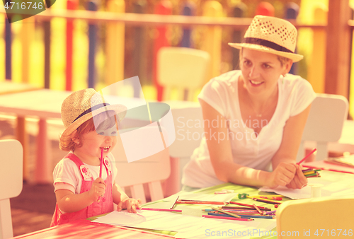 Image of mom and little daughter drawing a colorful pictures