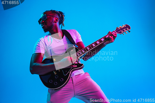 Image of Young african-american jazz musician playing the guitar