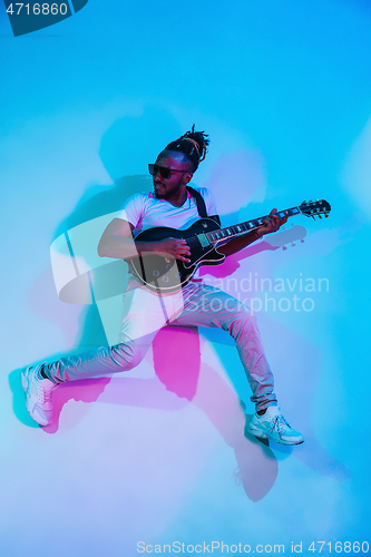 Image of Young african-american jazz musician playing the guitar