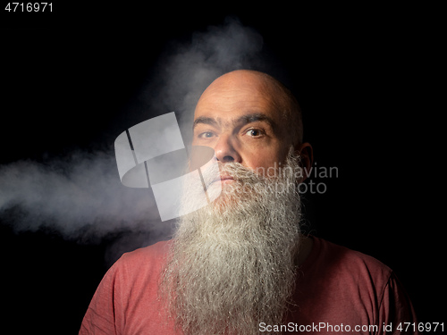 Image of bearded man gets smoke in his face portrait