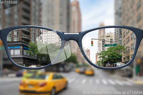 Image of glasses with sharp and blurred big city