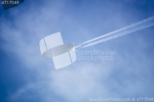Image of blue sky with plane in the clouds