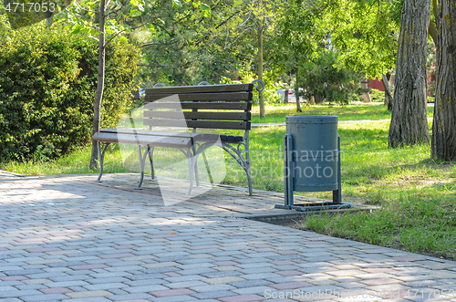 Image of A shop in the park, there is a street trash can next to it