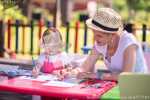 Image of mom and little daughter drawing a colorful pictures