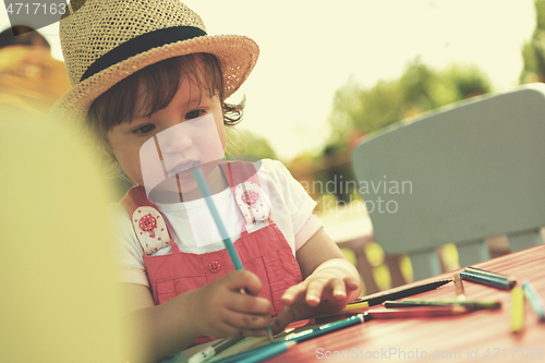 Image of little girl drawing a colorful pictures