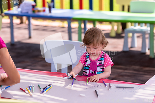 Image of little girl drawing a colorful pictures