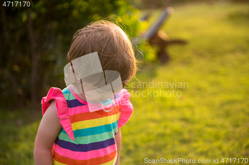 Image of little girl spending time at backyard