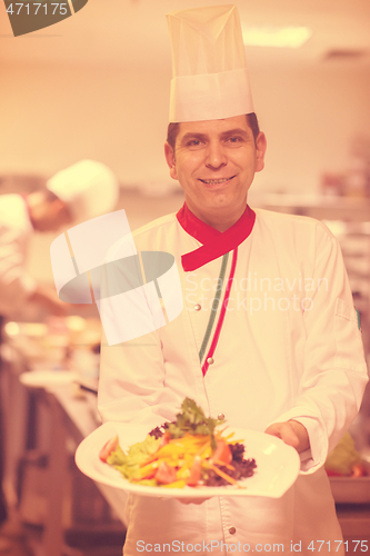 Image of Chef showing a plate of tasty meal