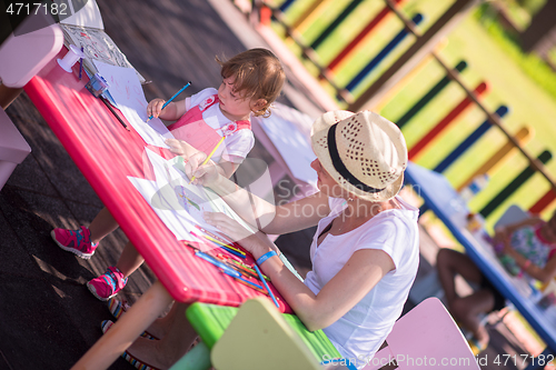 Image of mom and little daughter drawing a colorful pictures