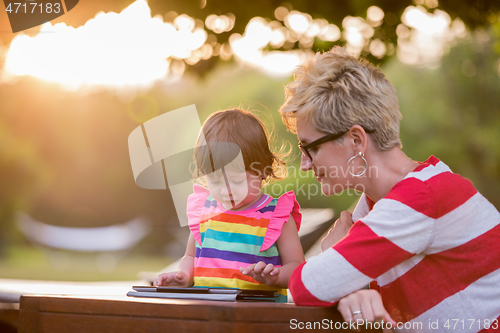 Image of mom and her little daughter using tablet computer