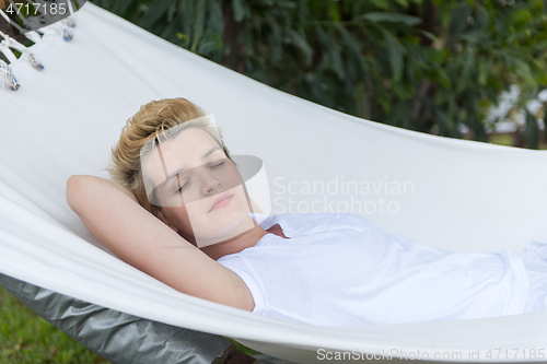Image of young woman resting on hammock