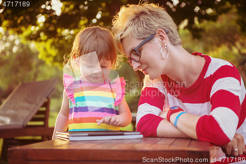 Image of mom and her little daughter using tablet computer