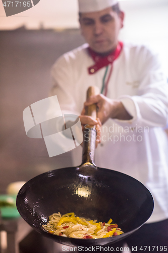 Image of chef flipping vegetables in wok