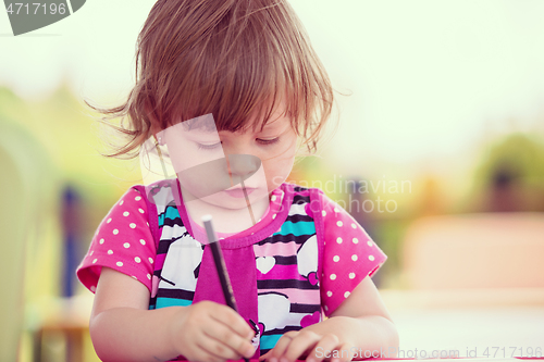 Image of little girl drawing a colorful pictures