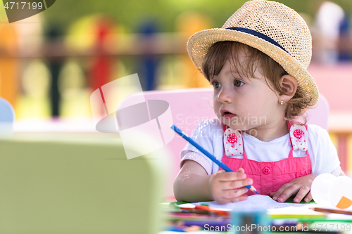 Image of little girl drawing a colorful pictures