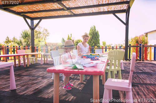 Image of mom and little daughter drawing a colorful pictures