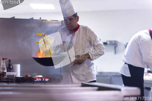 Image of chef flipping vegetables in wok