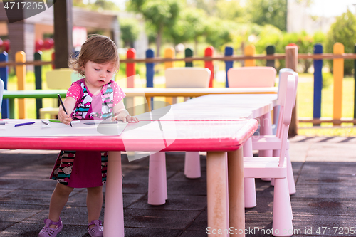 Image of little girl drawing a colorful pictures