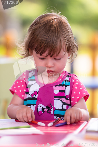 Image of little girl drawing a colorful pictures