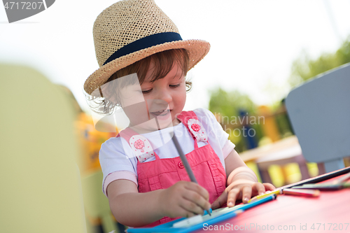 Image of little girl drawing a colorful pictures