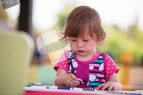 Image of little girl drawing a colorful pictures