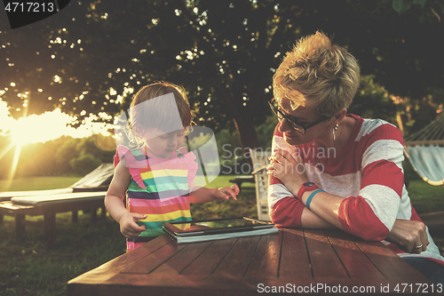 Image of mom and her little daughter using tablet computer