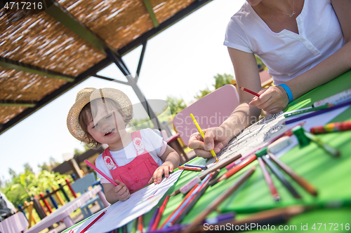 Image of mom and little daughter drawing a colorful pictures