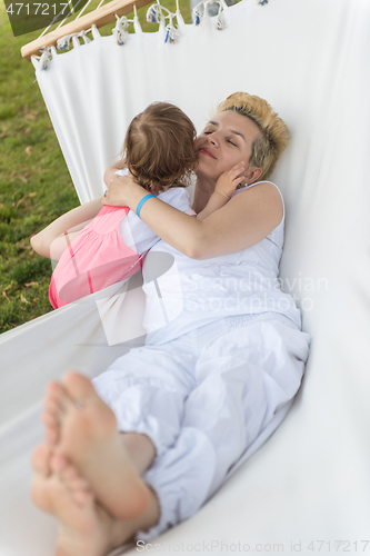 Image of mother and a little daughter relaxing in a hammock