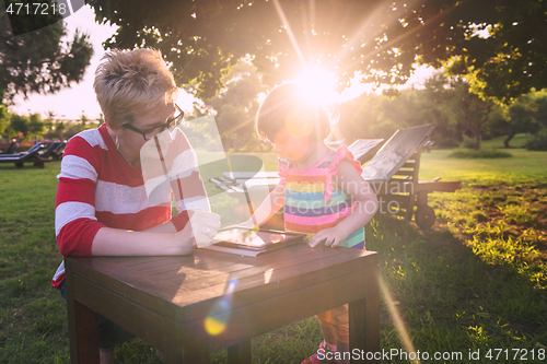 Image of mom and her little daughter using tablet computer