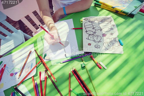 Image of closeup of hands drawing a colorful pictures