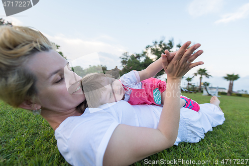 Image of mother and little daughter playing at backyard