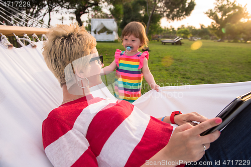 Image of mom and a little daughter relaxing in a hammock