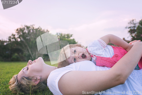 Image of mother and little daughter playing at backyard