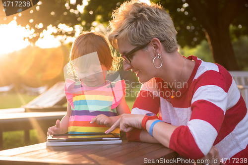 Image of mom and her little daughter using tablet computer