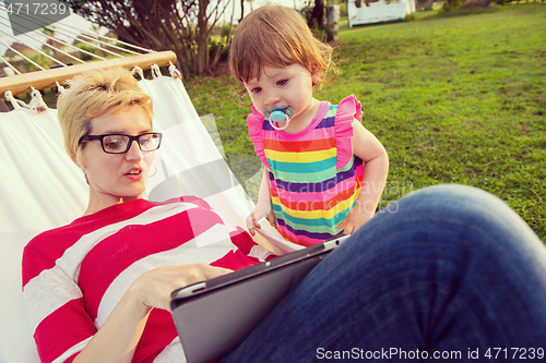 Image of mom and a little daughter relaxing in a hammock