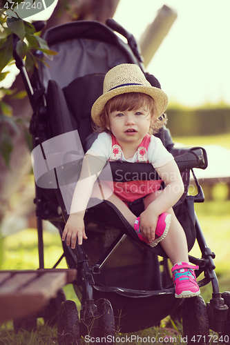 Image of baby girl sitting in the baby stroller