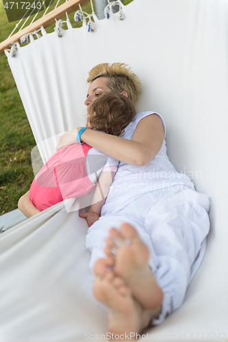 Image of mother and a little daughter relaxing in a hammock