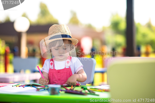 Image of little girl drawing a colorful pictures