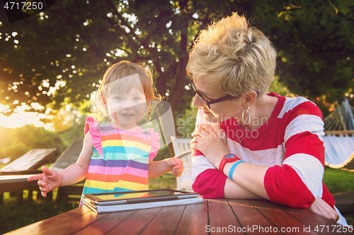 Image of mom and her little daughter using tablet computer