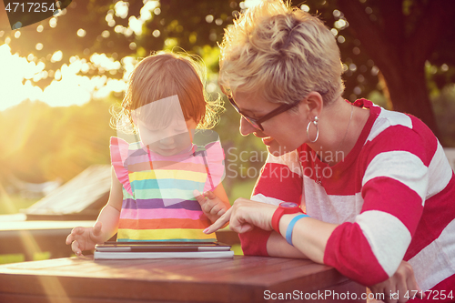 Image of mom and her little daughter using tablet computer