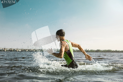 Image of Professional triathlete swimming in river\'s open water