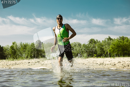 Image of Professional triathlete swimming in river\'s open water