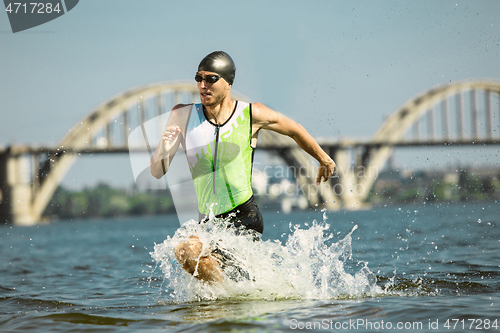 Image of Professional triathlete swimming in river\'s open water