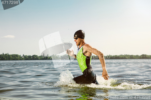 Image of Professional triathlete swimming in river\'s open water