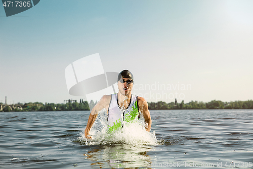 Image of Professional triathlete swimming in river\'s open water