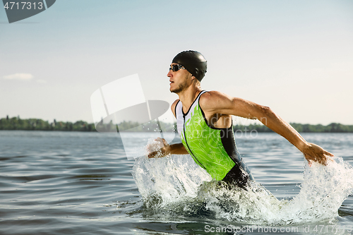 Image of Professional triathlete swimming in river\'s open water