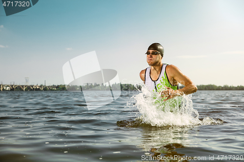 Image of Professional triathlete swimming in river\'s open water